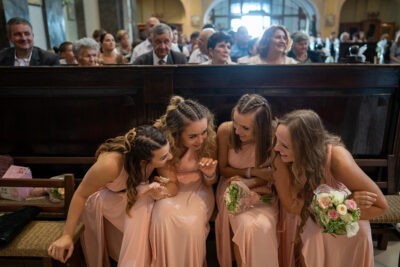Koszorúslányok a templomban sugdolóznak az esküvői ceremónia alatt