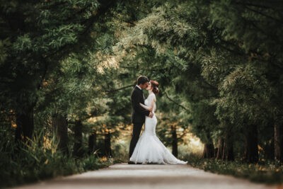 Menyasszony és vőlegény csókolózik az erdei úton