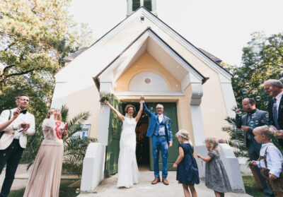 A templomból kijőve emeli magasba a kezét az ifjú pár