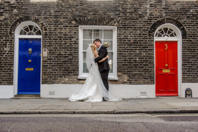 A házaspár csókolózik a jellegzetes londoni ajtók elött