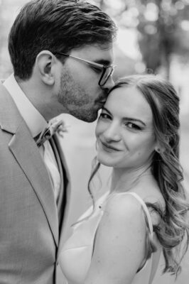 A férj puszit ad a felesége homlokára az esküvőjükön